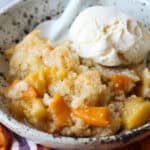 Homemade peach cobbler served with vanilla ice cream.