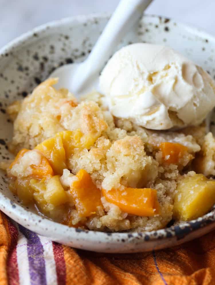 Homemade peach cobbler served with vanilla ice cream.