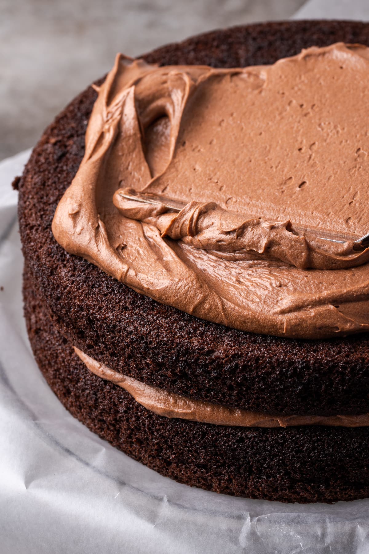 Chocolate frosting spread over a chocolate layer cake.