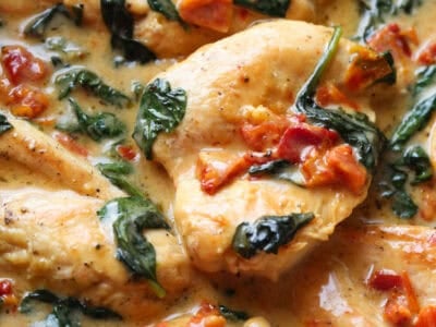 Easy Tuscan Chicken Recipe is made in a cream sauce with spinach and sun dried tomatoes