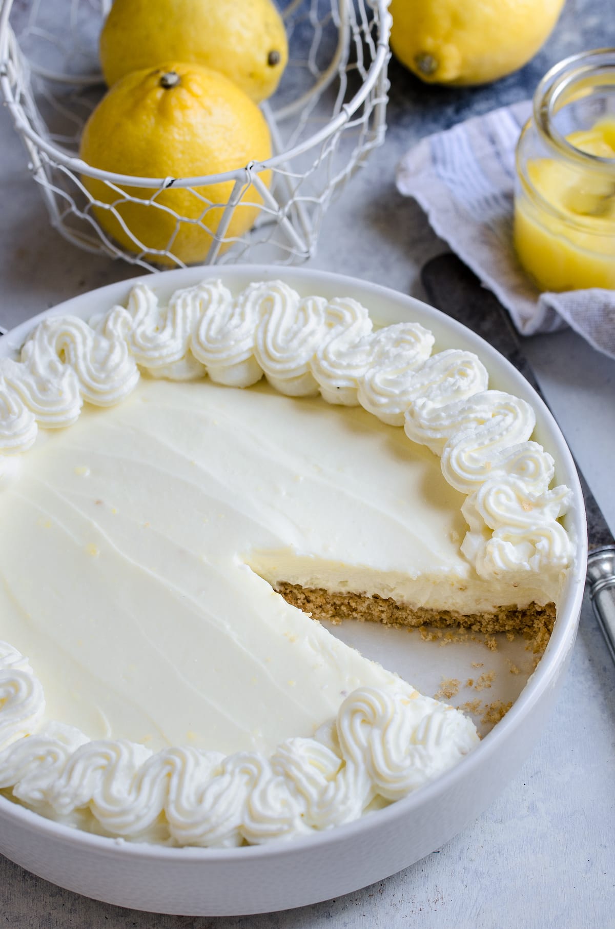 A lemon cream pie with a slice missing.