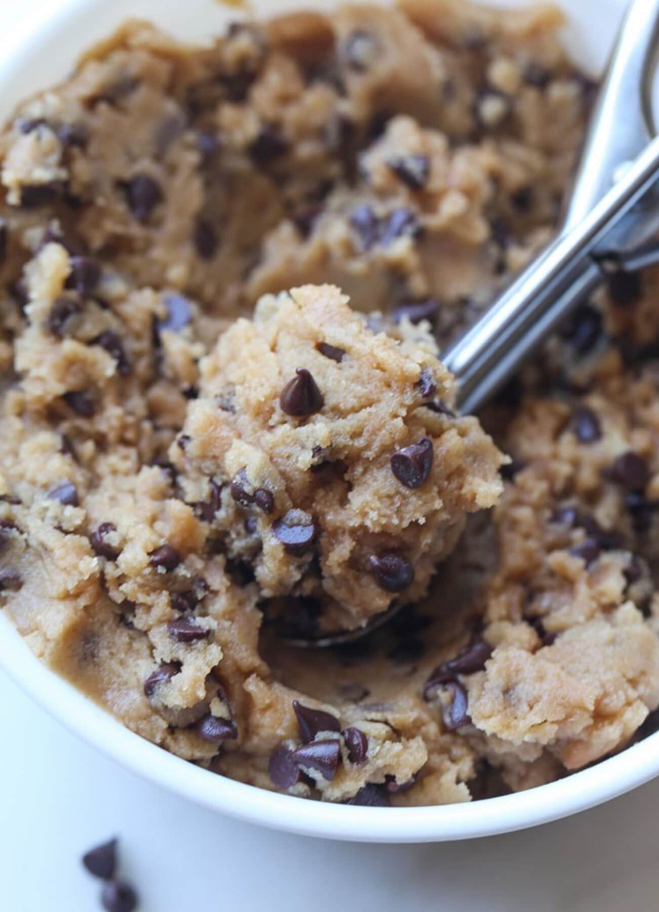 A bowl full of egg free edible cookie dough with a cookie scoop.