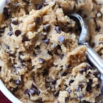 A bowl full of cookie dough with a cookie scoop.
