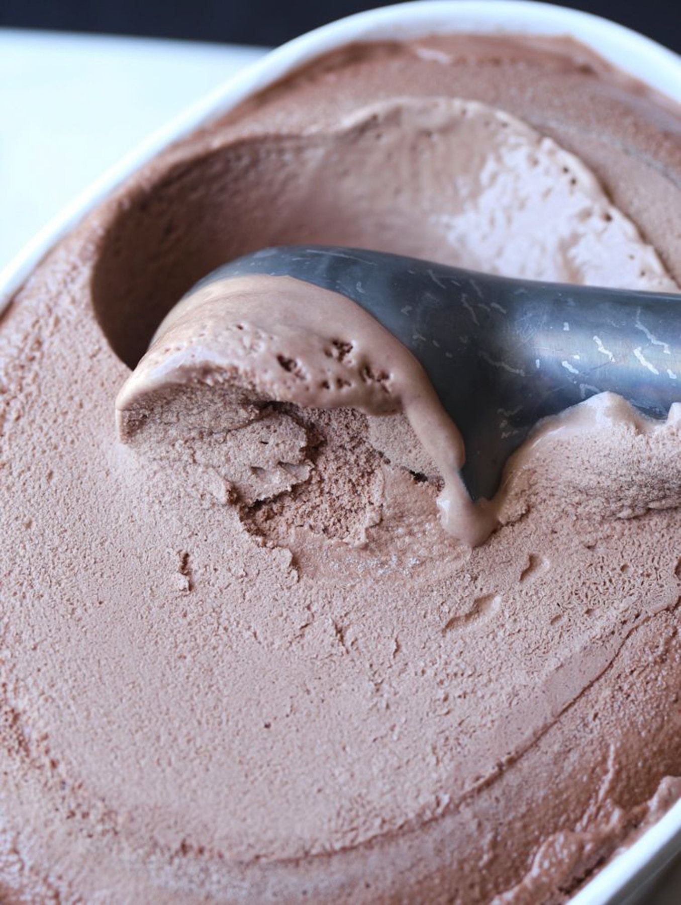 Chocolate ice cream scooped out of a tub