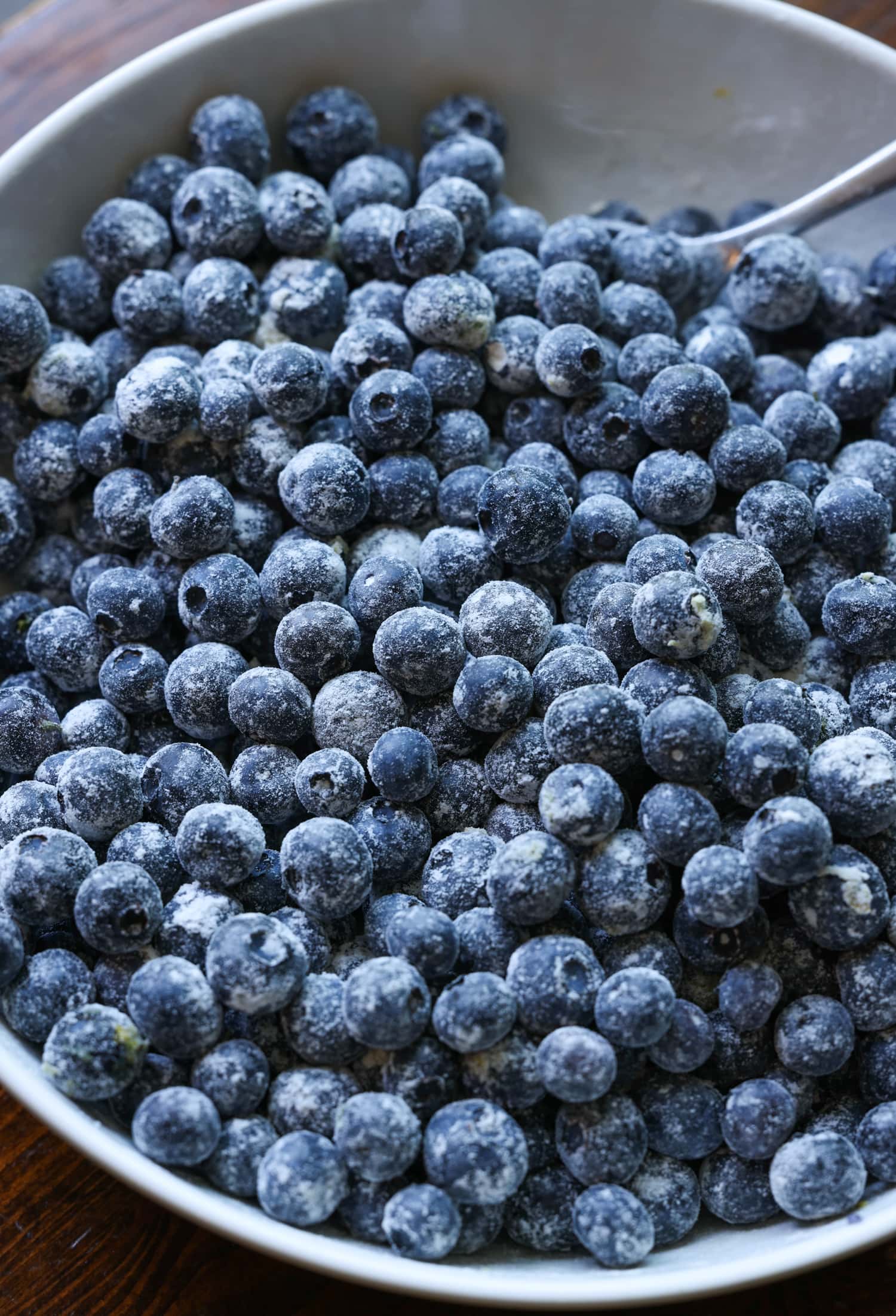 blueberries coated in sugar and flour in a white bowl