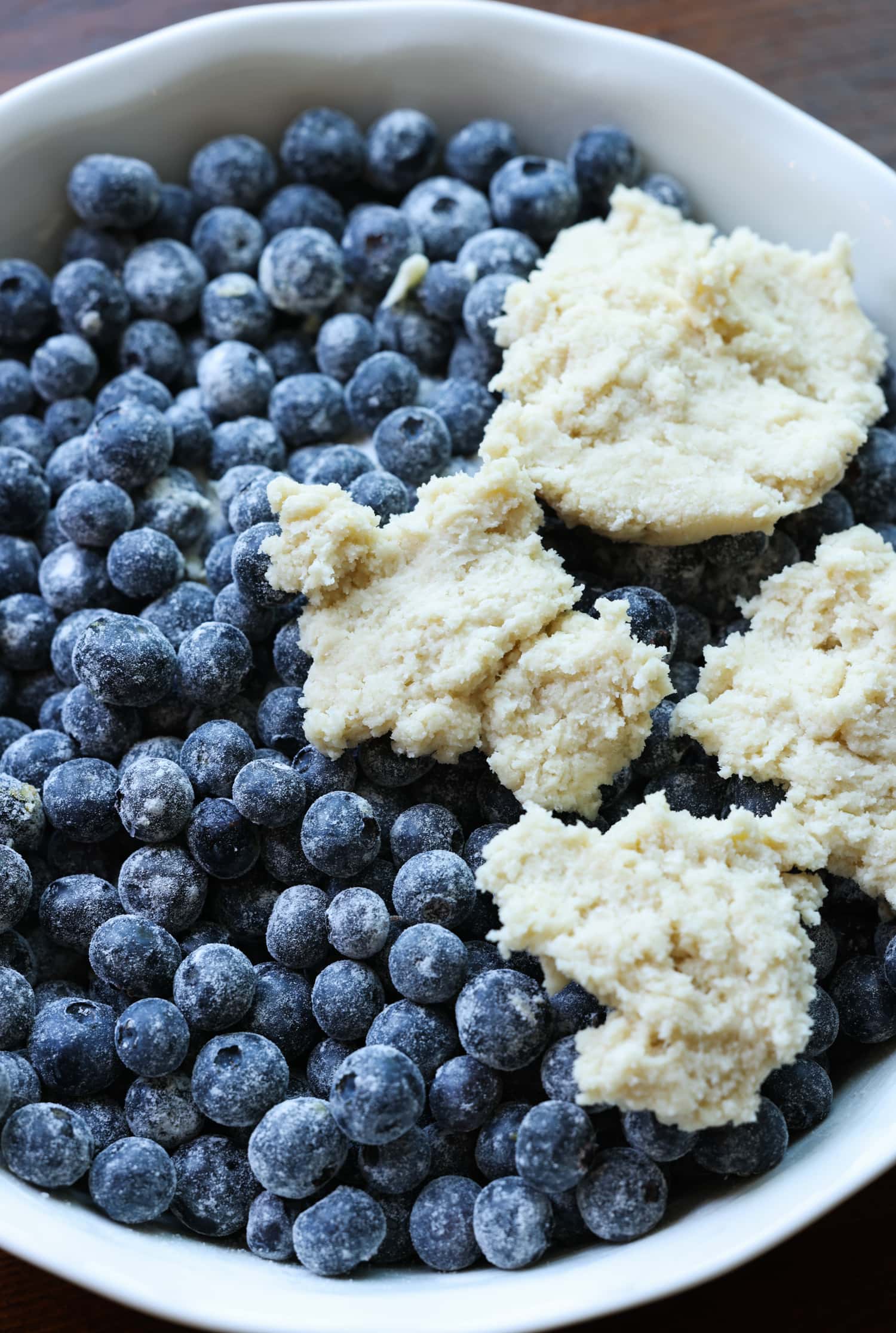 blueberries in a pie plate with pieces of dough on top