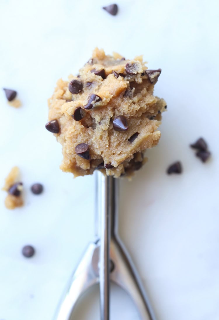 A cookie scoop full of edible chocolate chip cookie dough.