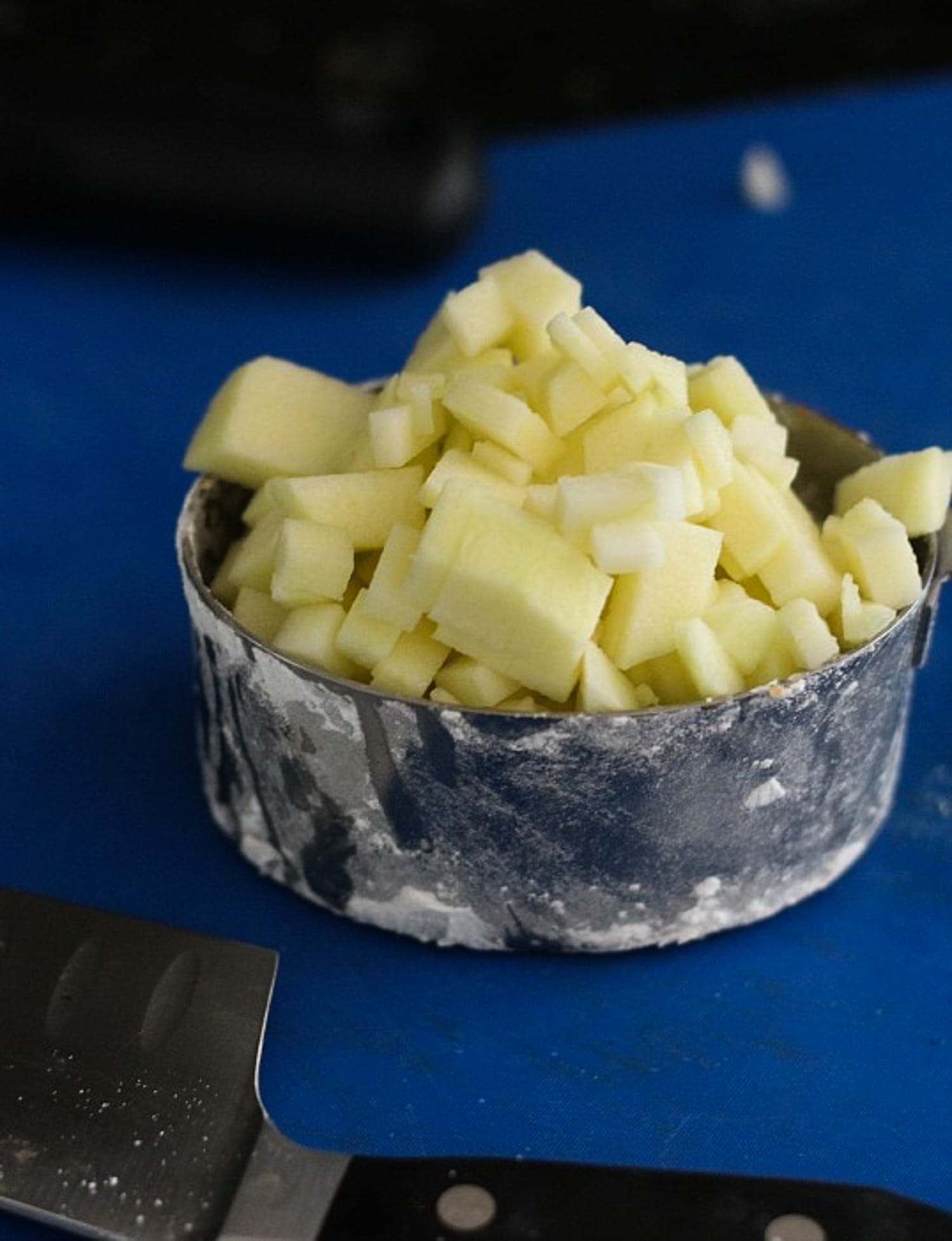 chopped apples in a measuring cup