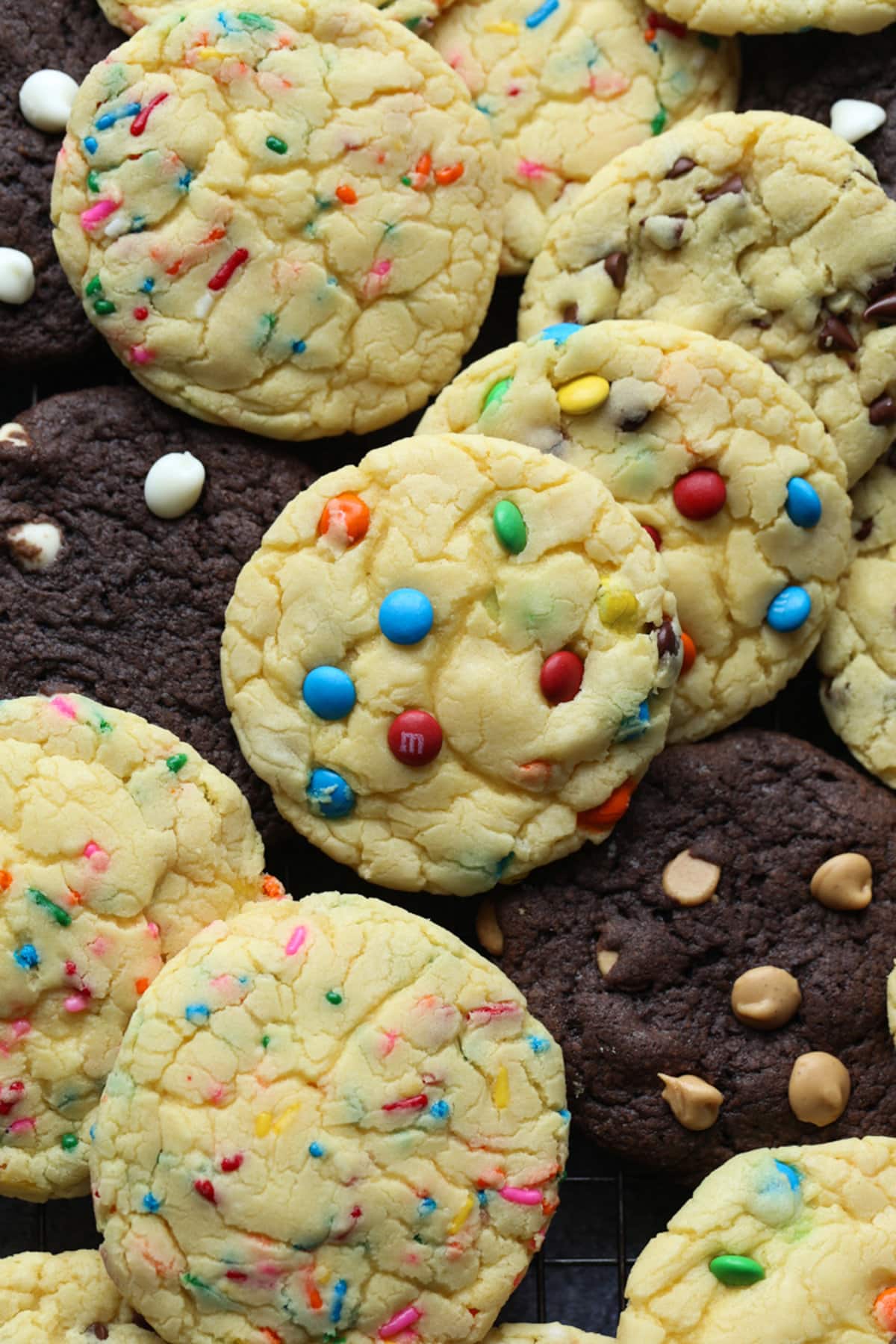Pile of cake mix cookies with M&Ms and sprinkles.