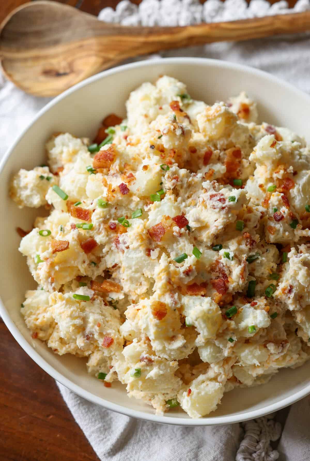 A bowl of potato salad with bacon and chives