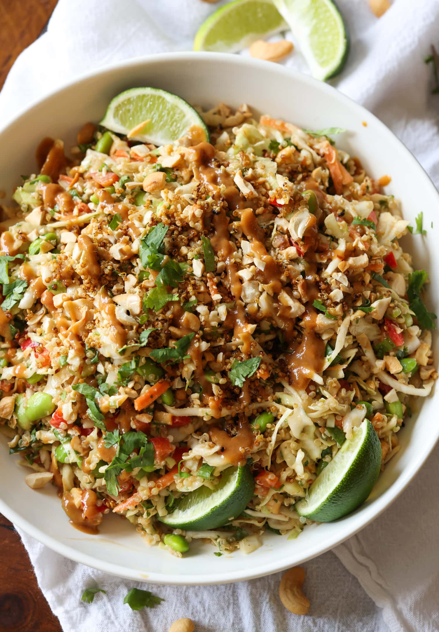 Thai Quinoa Salad in a bowl with lime wedges and chopped cilantro