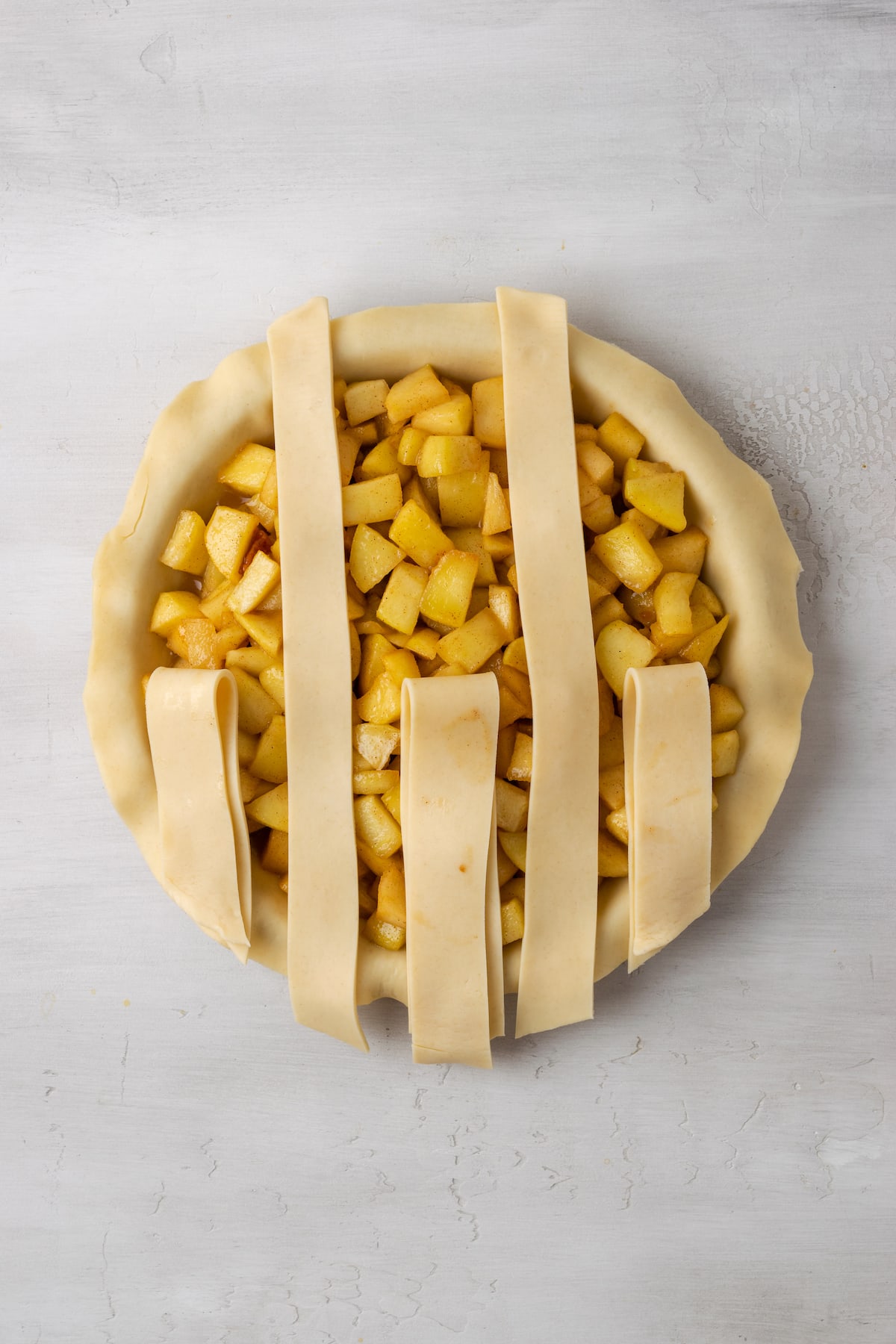 An apple pie with a partially completed lattice top.