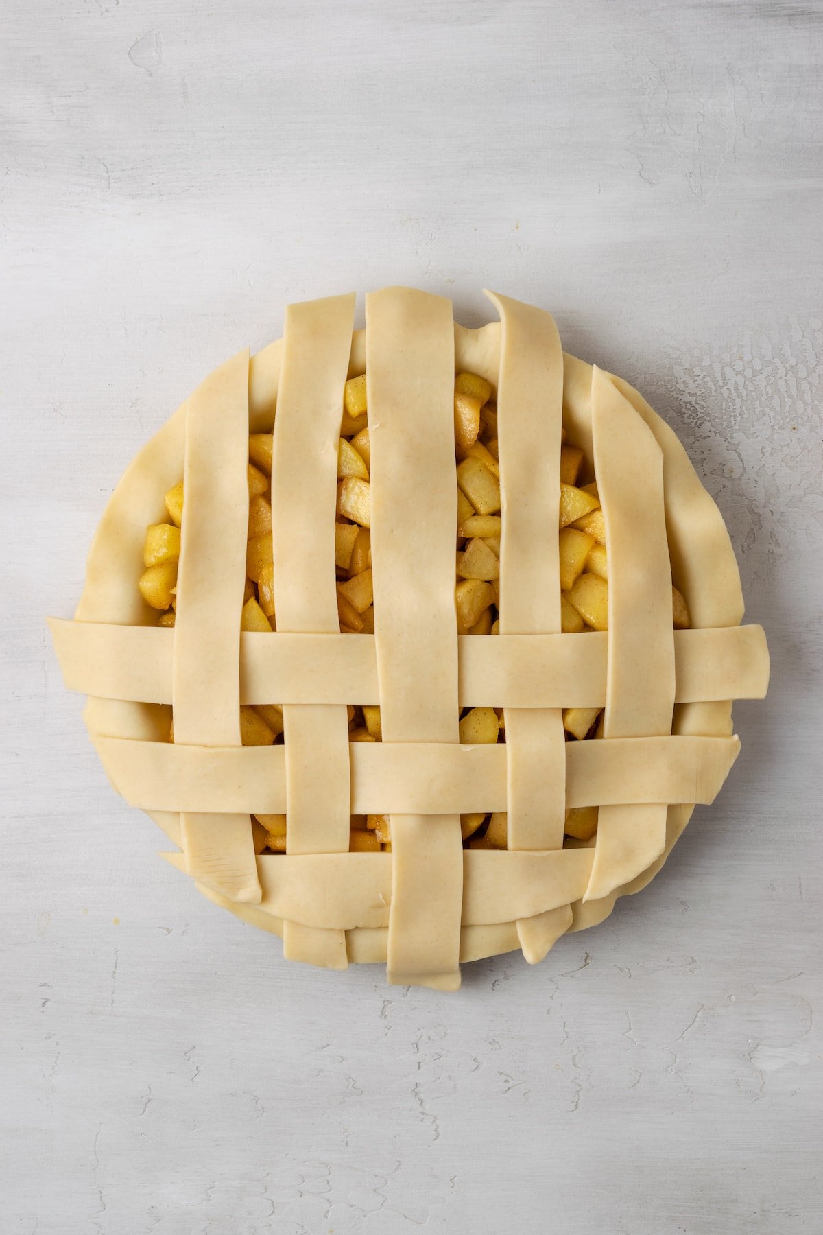 An apple pie with a partially completed lattice top.