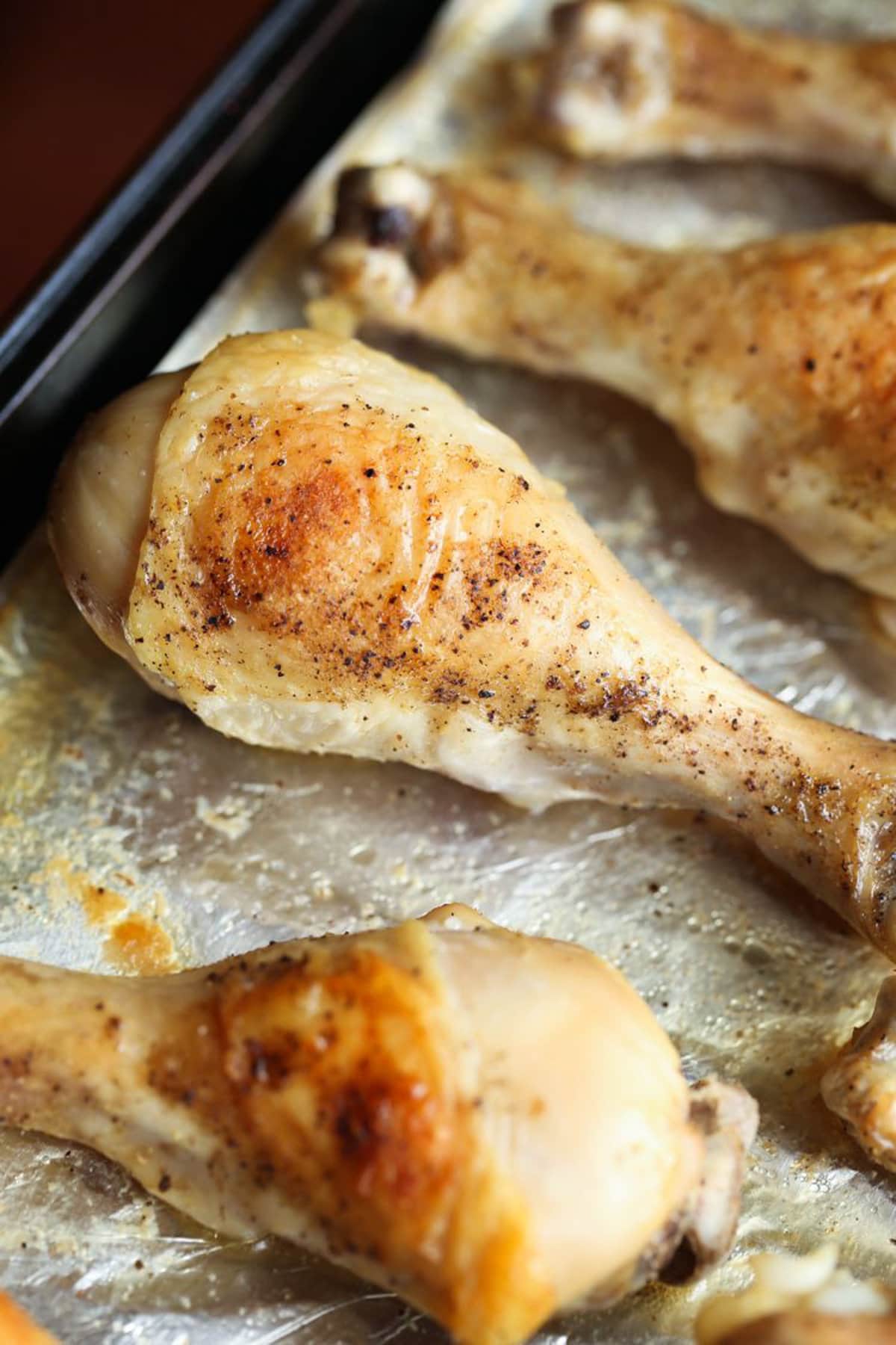 Oven baked chicken legs on a baking sheet