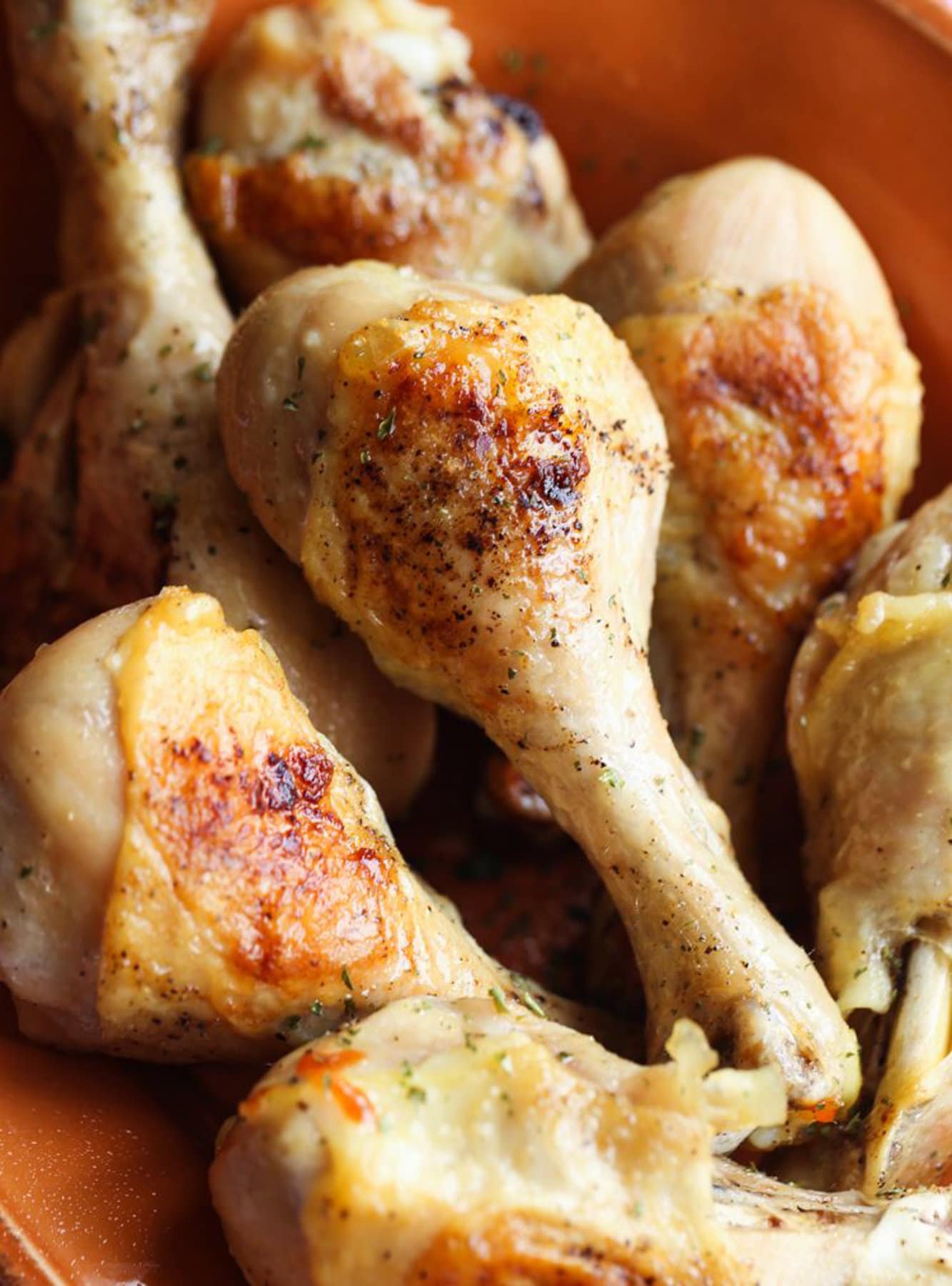 Baked chicken drumsticks on a serving dish.