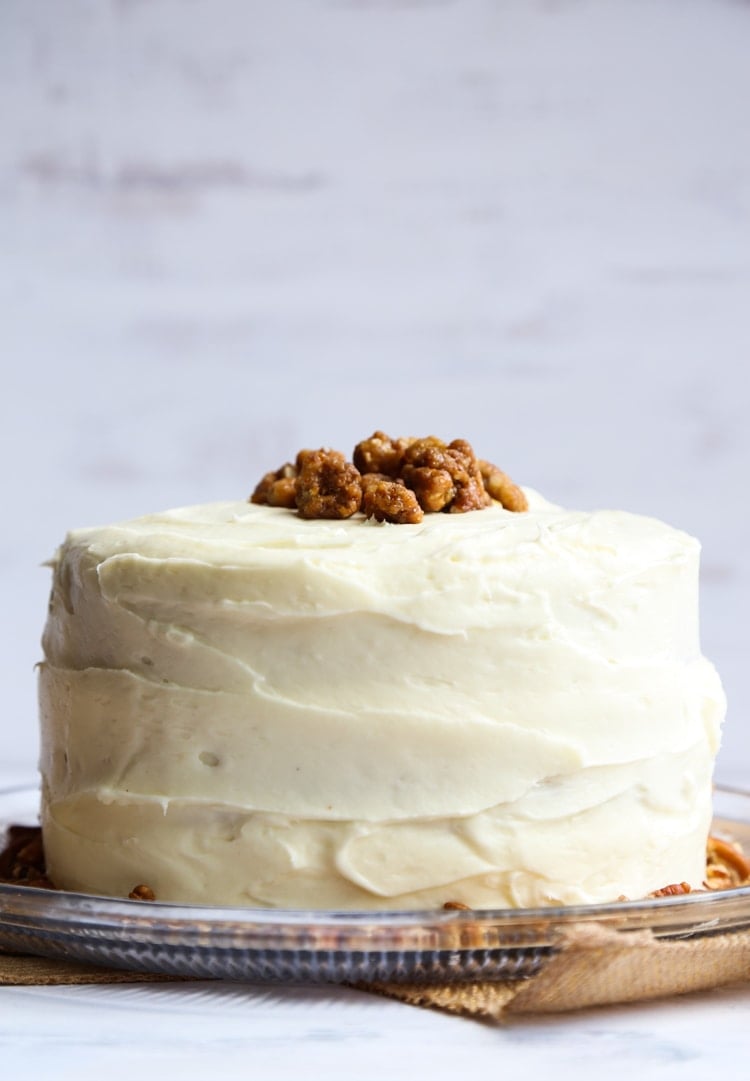 A whole frosted Hummingbird Cake topped with pecans