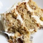 A slice of Hummingbird Cake on a plate with a fork.
