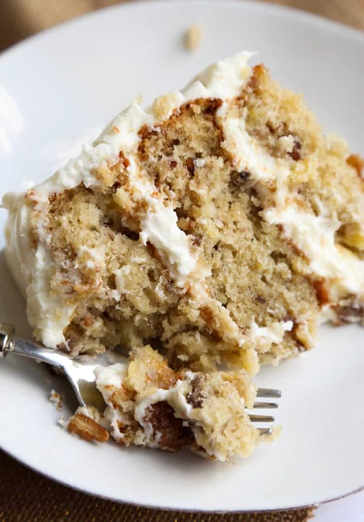 A slice of Hummingbird Cake on a plate with a fork.