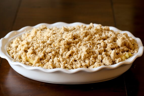 Apple Crisp topped with an oat streusel in a white casserole dish before being baked