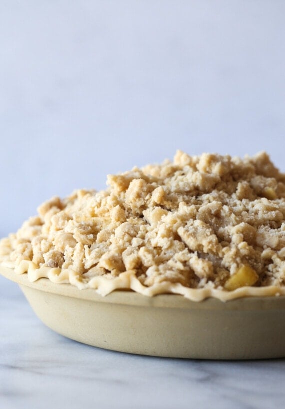 An unbaked apple pie with crumb topping