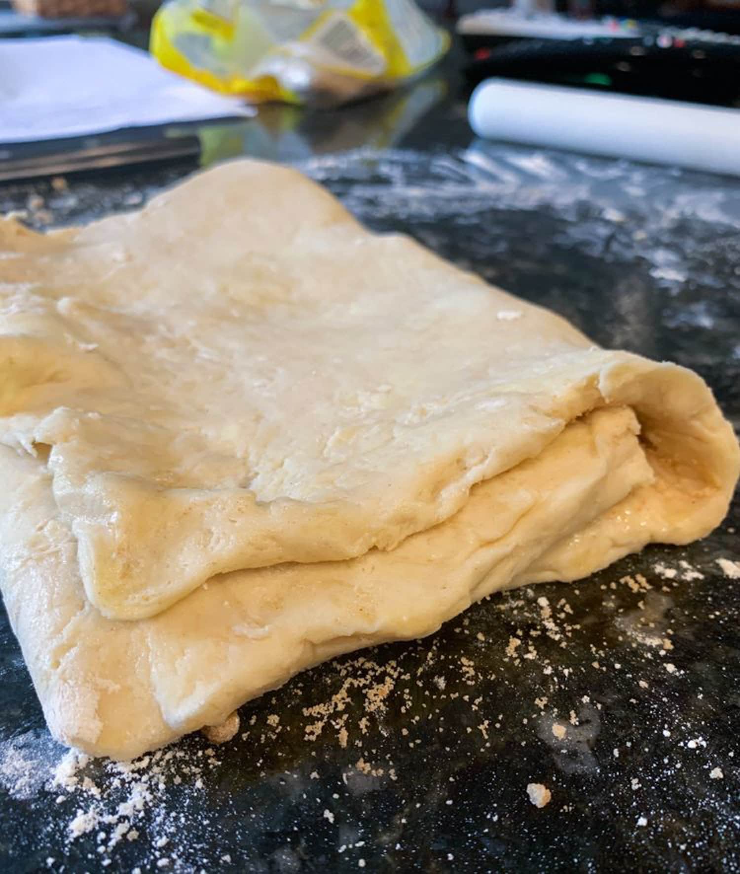 Biscuit dough flattened out on a floured surface