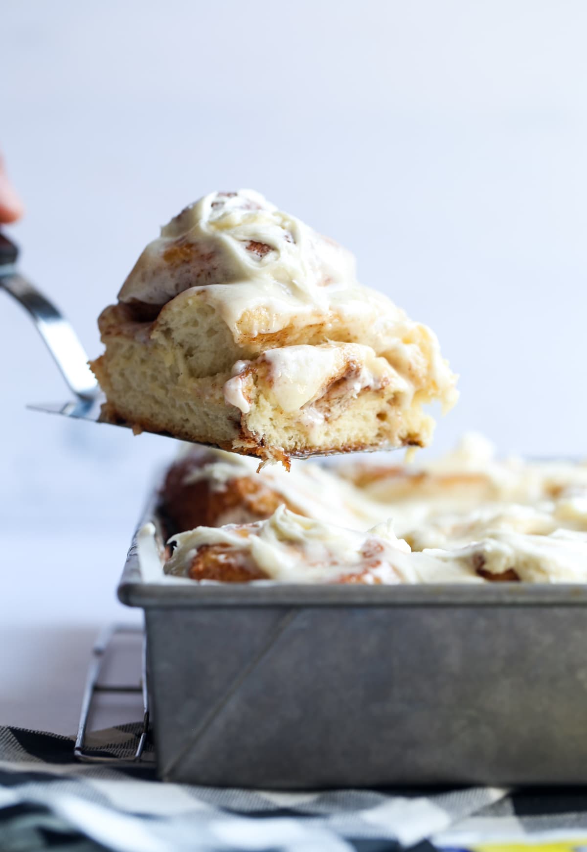 Serving a cinnamon bun on a spatula from the 9x13 pan