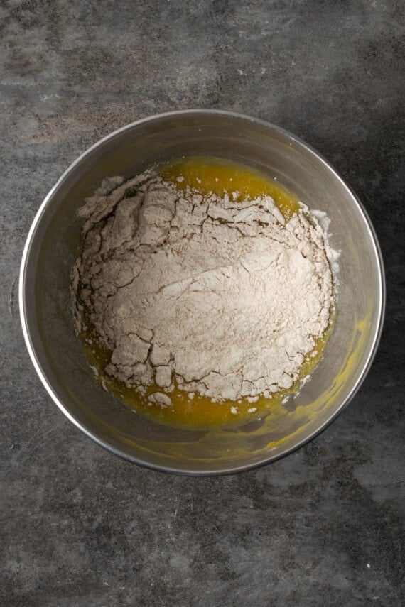 Dry ingredients added to wet cupcake batter in a mixing bowl.