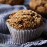 Close up of a bran muffin with more muffins in the background.