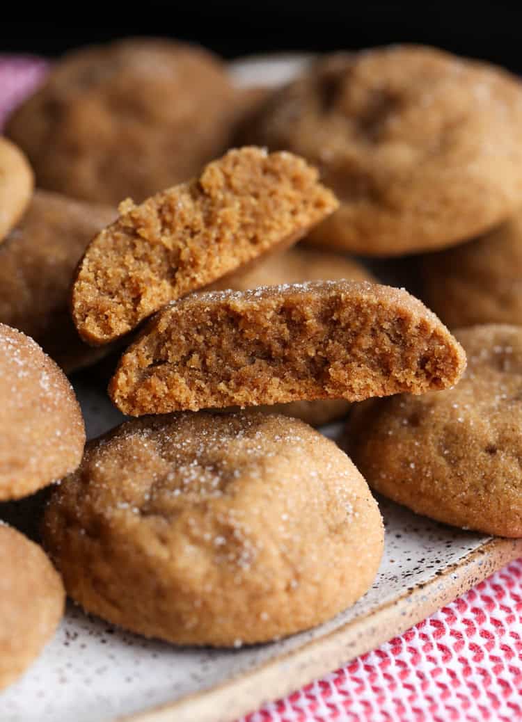 Soft Gingerdoodles stacked on a platter, with one cookie broken in half.