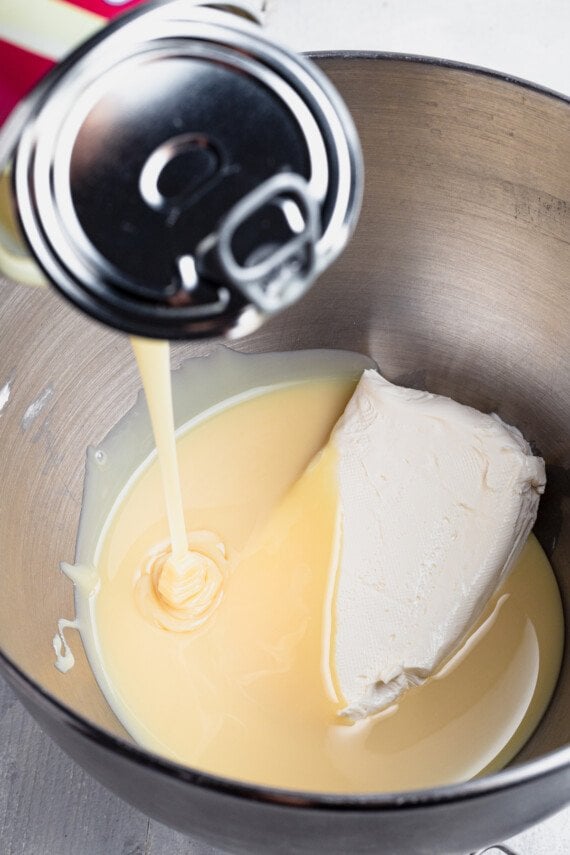 Cream cheese and sweetened condensed milk in a mixing bowl.