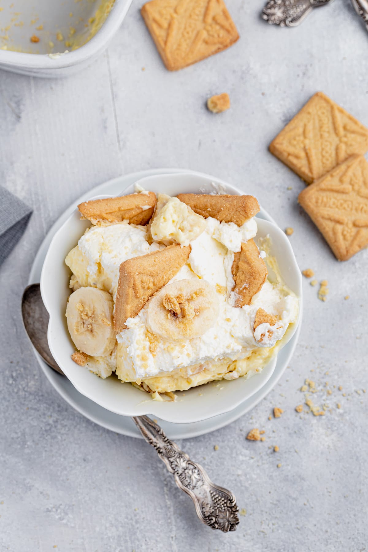 This is the BEST homemade banana pudding recipe! Layers of ripe bananas, cookies, and fluffy pudding make this a favorite no-bake dessert. Cookies, banana slices, and pudding in a bowl.