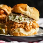 A shredded BBQ Chicken sandwich on a bun with cole slaw