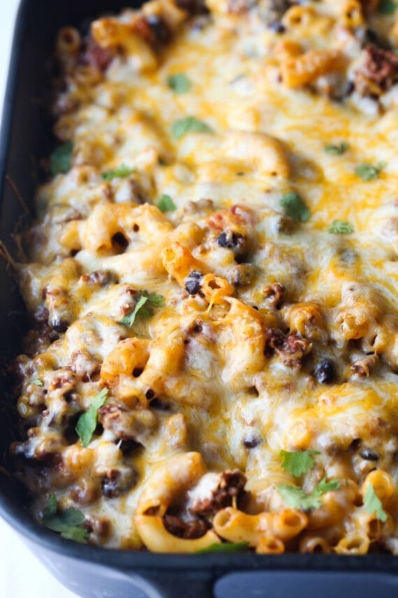 Baked chili mac and cheese in a black casserole dish.