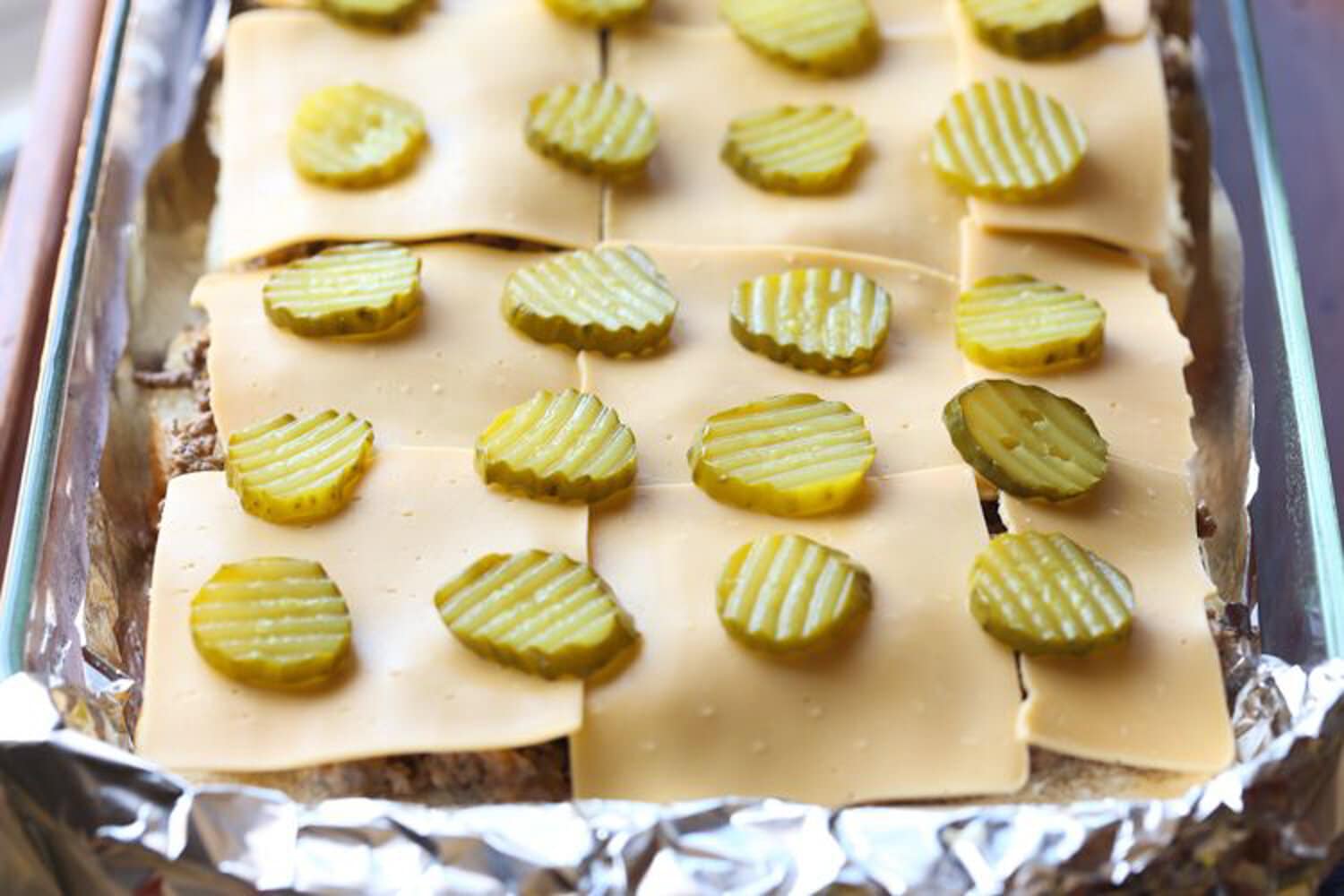 Cheeseburger sliders topped with pickles 