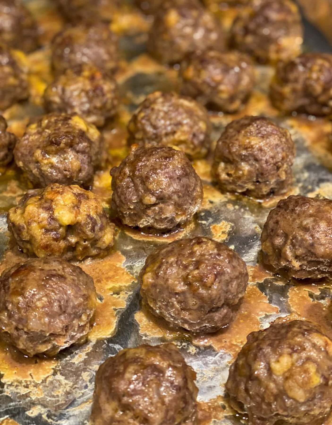 Cooked meatballs showing melted cheese.