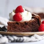 Flourless Chocolate Cake topped with whipped cream and raspberries