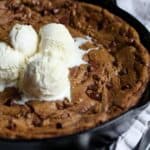 Pizookie topped with melted ice cream in a skillet