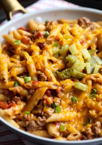 Cheeseburger Pasta topped with cheese, pickles, and green onions
