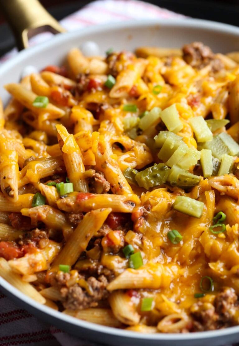 Cheeseburger pasta topped with cheese, pickles and green onions