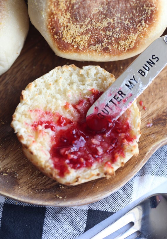 A fork split English muffin with jam