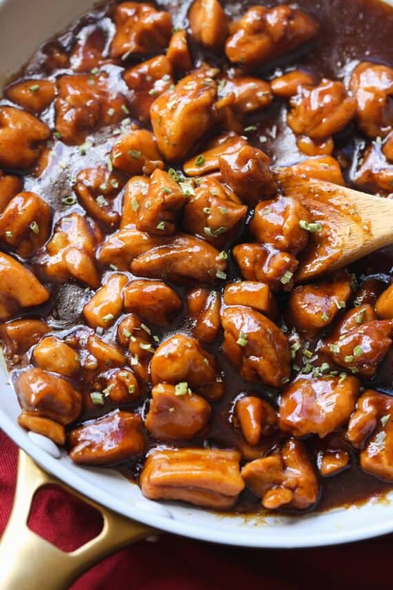 Bourbon Chicken in a skillet garnished with chives