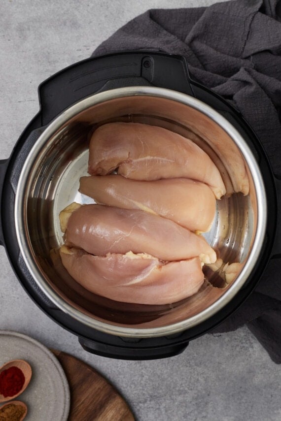 Raw chicken breasts in the bottom of an Instant Pot.