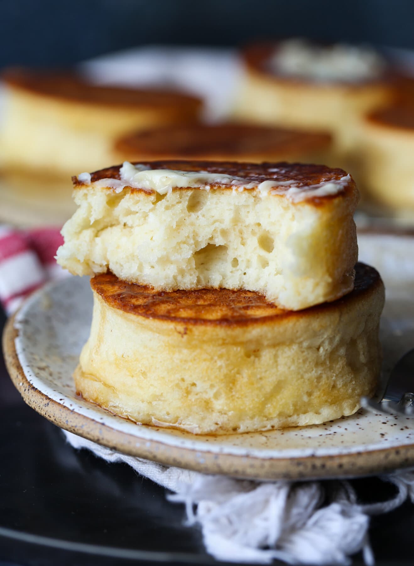 Two stacked soufflé pancakes with one broken in half showing the fluffy interior.