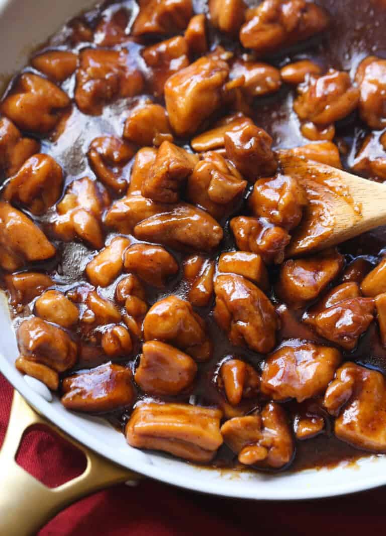 Bourbon Chicken in a skillet garnished with chives