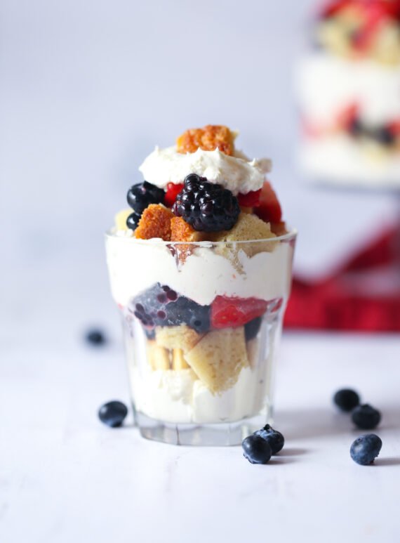 Individual layered dessert with cake, berries, and cheesecake mousse