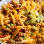 Cheeseburger Pasta topped with cheese, pickles, and green onions