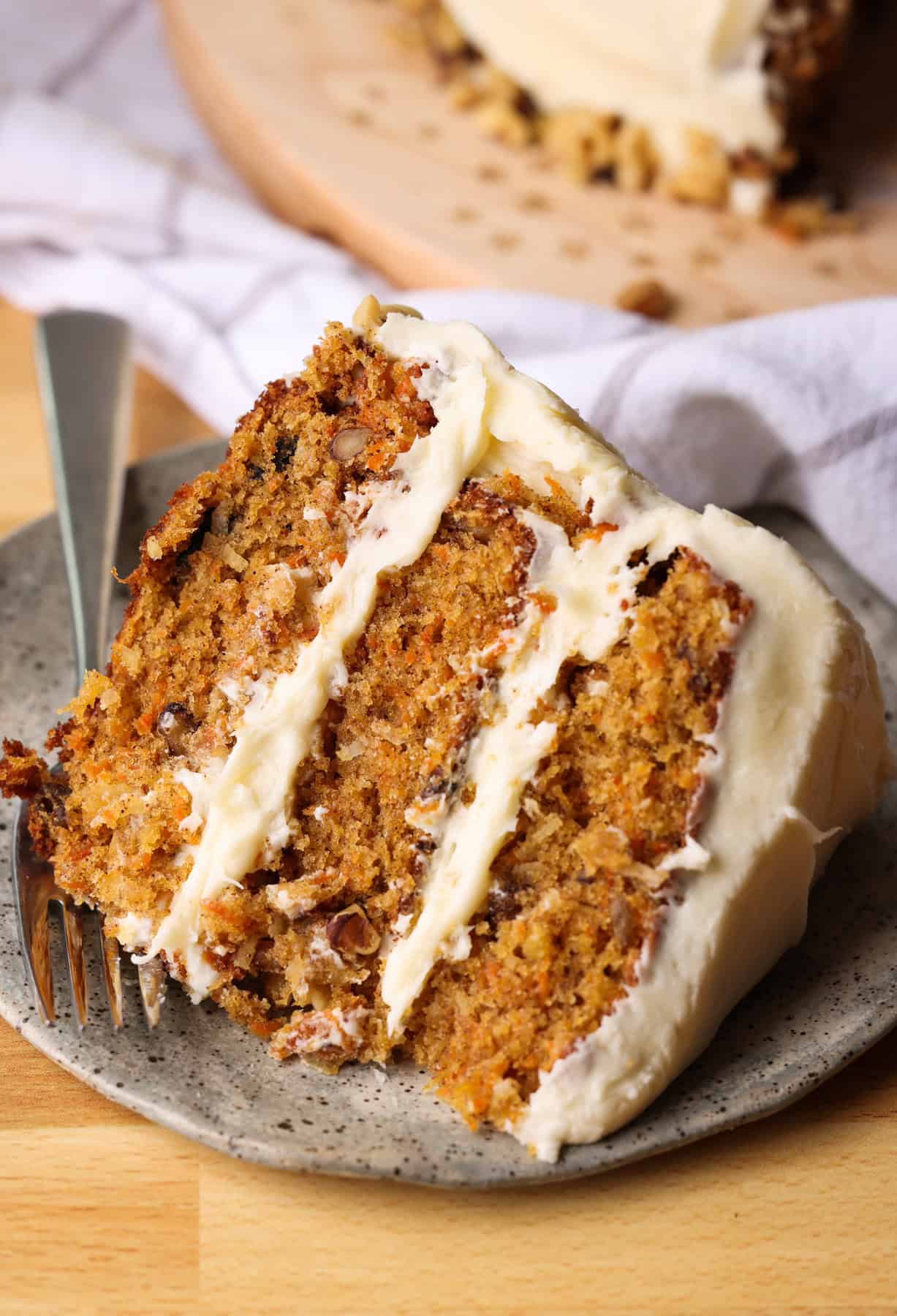 a slice of carrot cake on a plate with a fork