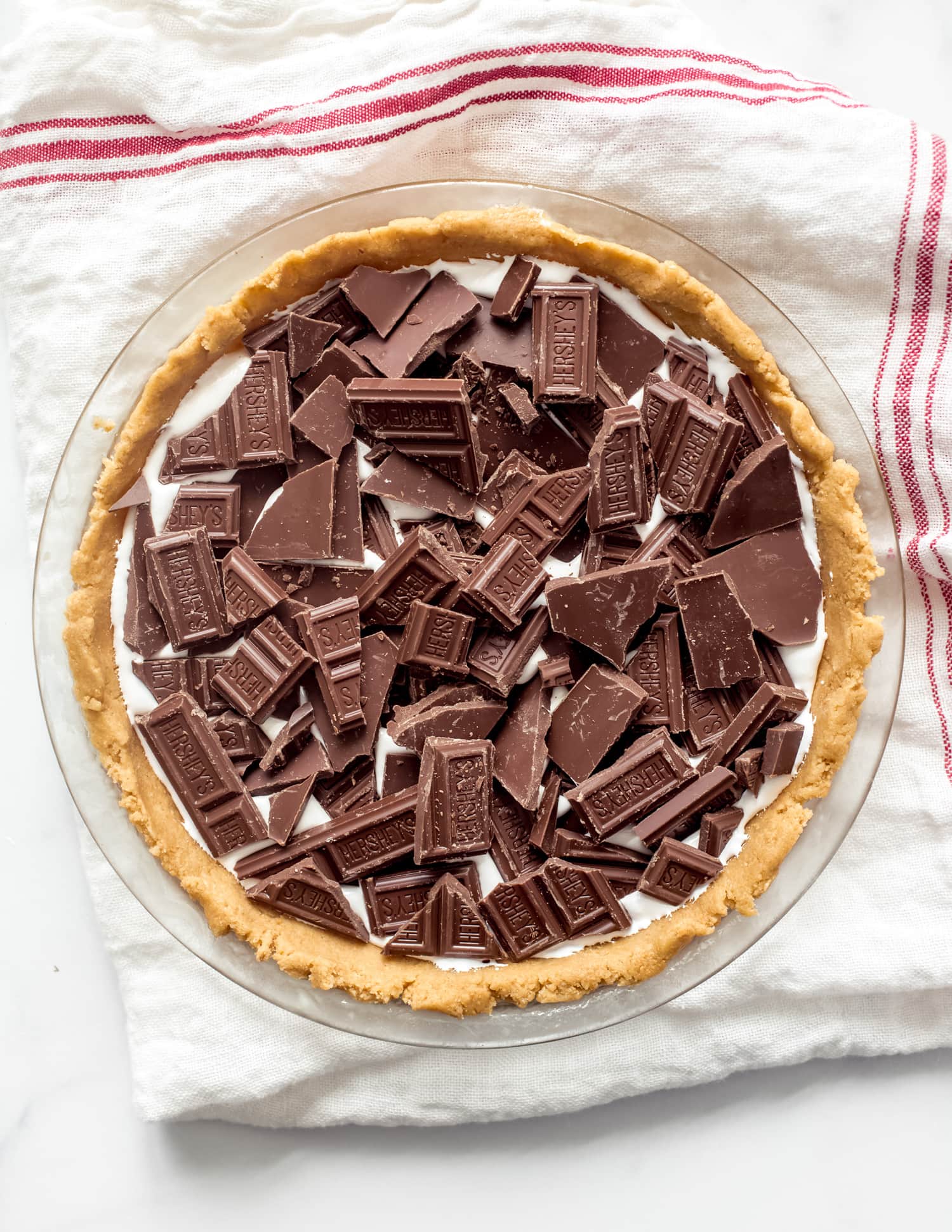 A pie from above filled with marshmallow fluff and Hershey's chocolate before being baked.