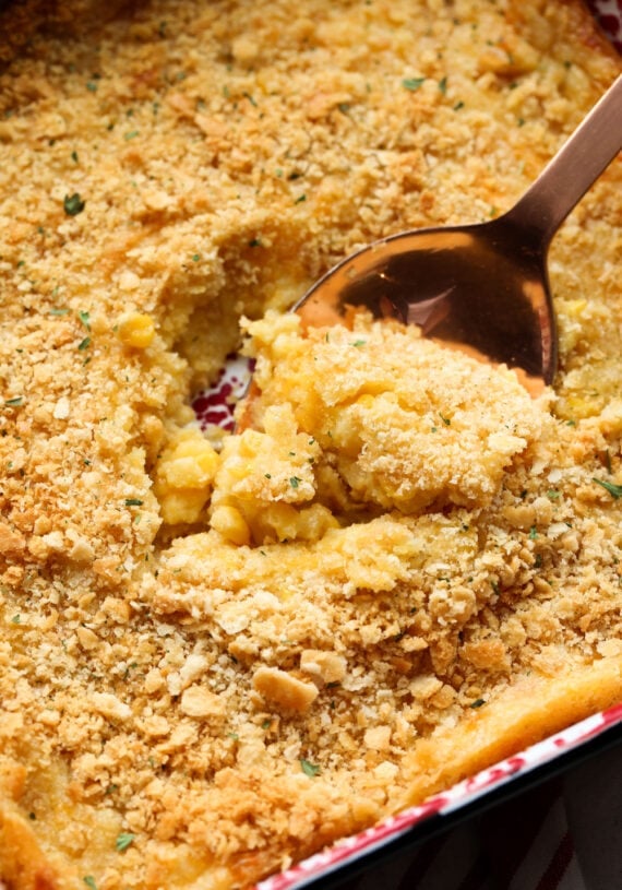 Close up of a wooden spoon scooping corn casserole