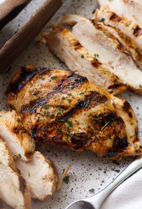 A piece of Tequila Lime Chicken on a plate and slices cut 